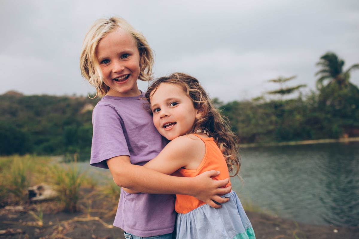 Großer Bruder umarmt seine kleine Schwester.