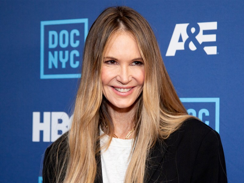 Elle McPherson mit langem, glatten Haar, die in die Kamera lächelt.