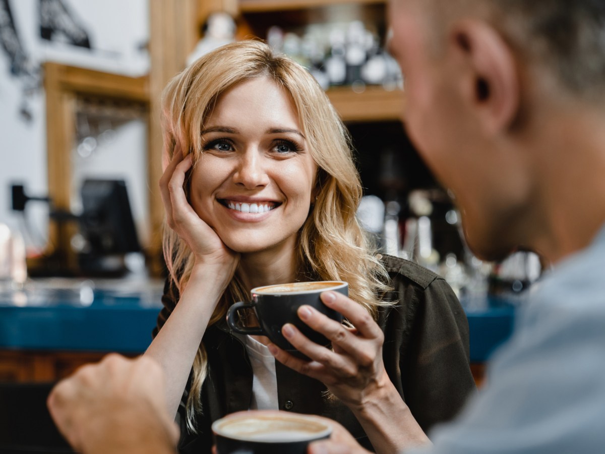 Eine Frau mit einer Kaffeetasse in der Hand, auf einem Date.