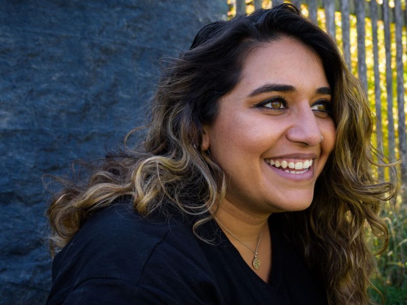 Lächelnde Frau mit dunklen Haaren und Locken.