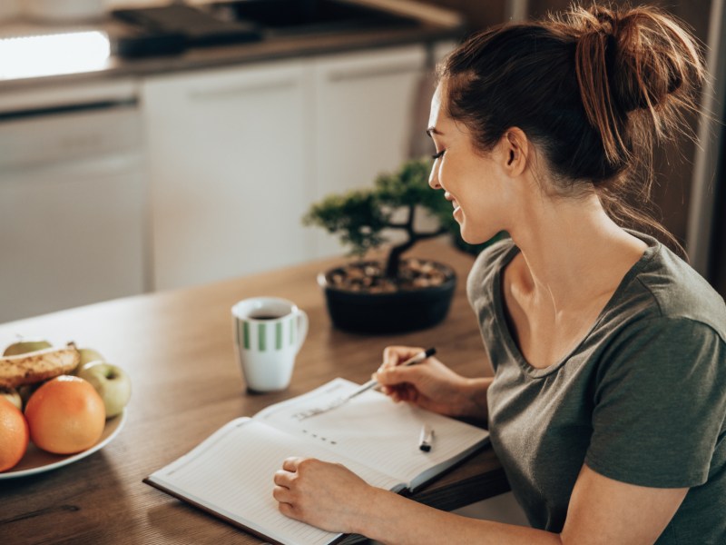 Frau sitzt am Tisch und schreit eine To-Do-Liste