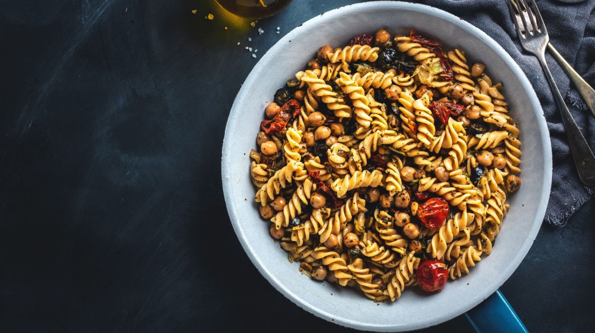 Nudelsalat mit Tomaten, Oliven und Kirchererbsen in einer Pfanne