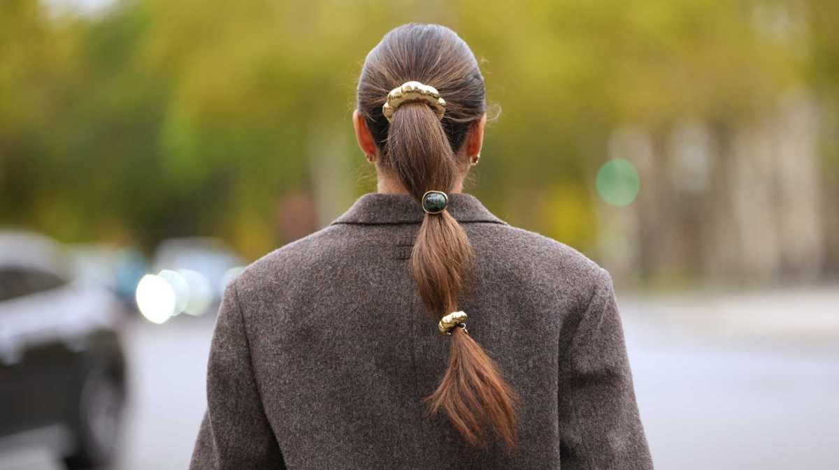 Lange braune Haare sind zu einem Zopf gebunden