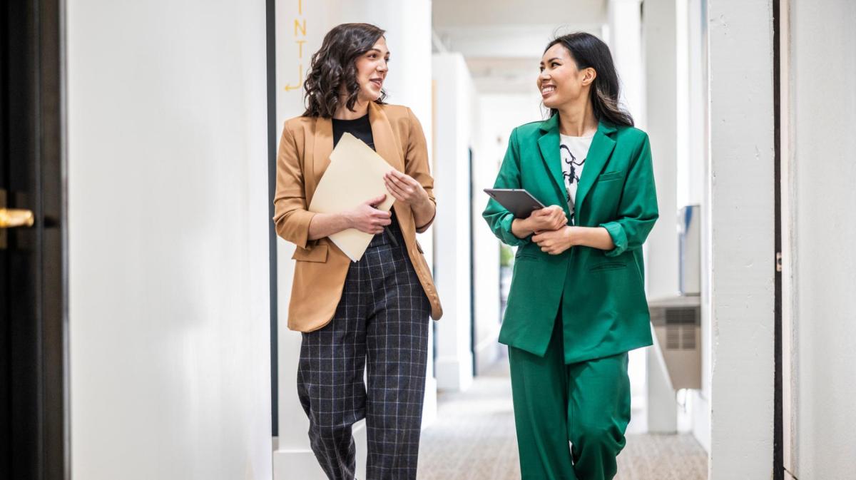 Zwei Frauen mit modernen und stylischen Outfits im Büro.