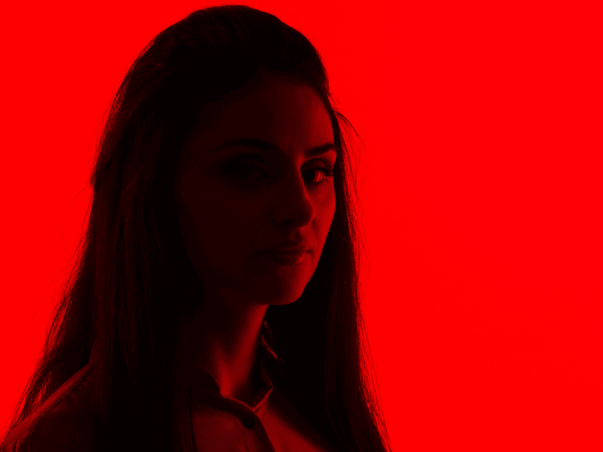 Frau blickt sexy vor einem roten Hintergrund
