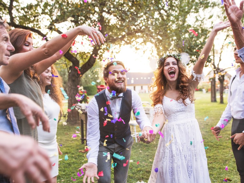 Hochzeitspaar wird mit Konfetti beworfen.