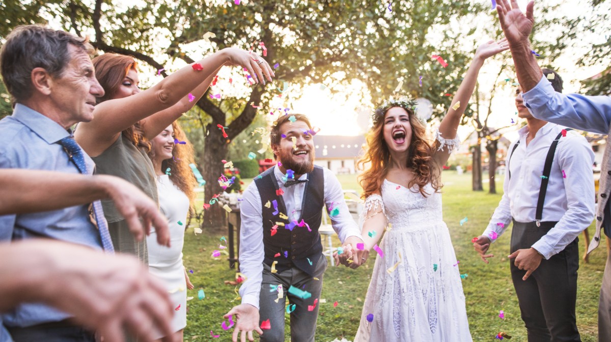 Hochzeitspaar wird mit Konfetti beworfen.