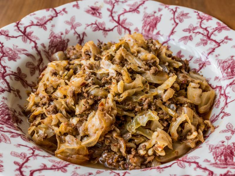 Durchgebratenes Hackfleisch mit Weißkohl auf einem Teller angerichtet.