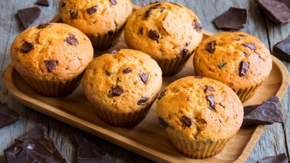 Muffins mit Schokostückchen auf einem Holzbrett.