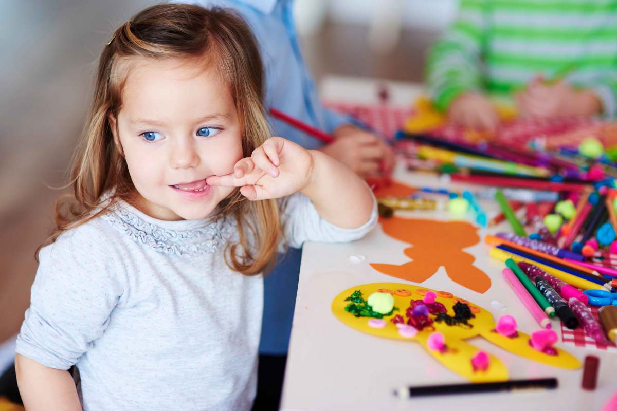 Kleines Mädchen an einem Basteltisch.