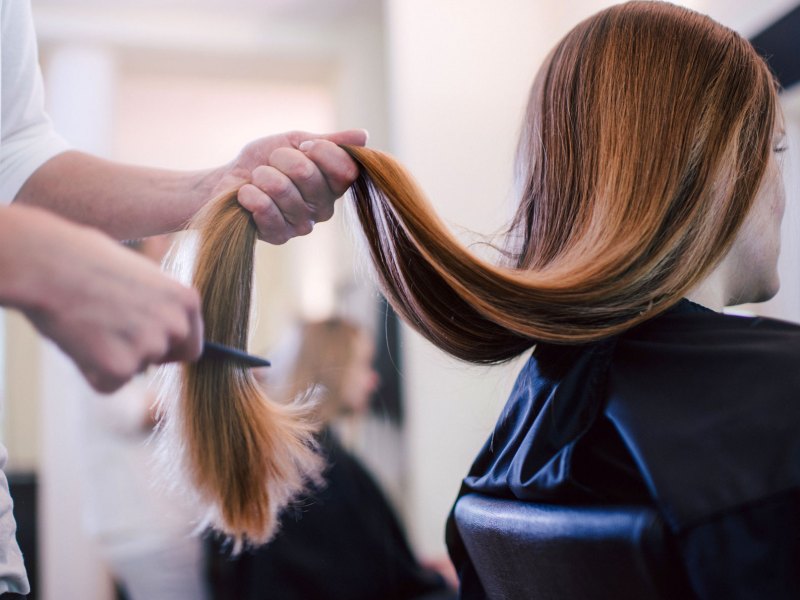 Frau mit sehr langem Haar beim Frisör