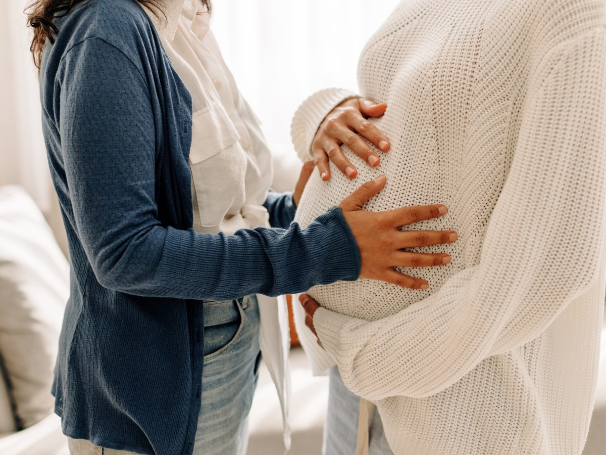 Symbolbild f&uuml;r Leihmutter: Eine Frau legt H&auml;nde auf den Babybauch einer anderen Frau