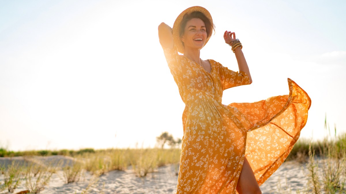 Frau in Kleid am Strand; eines der Sternzeichen, die den Sommer lieben