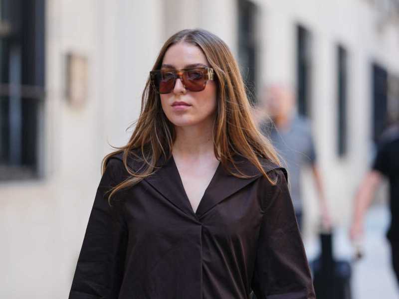 Frau trägt langes, glattes, mittig gescheiteltes braunes Haar mit leichtem Rotstich