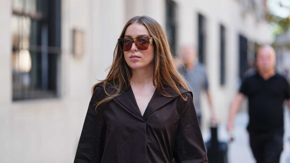 Frau trägt langes, glattes, mittig gescheiteltes braunes Haar mit leichtem Rotstich