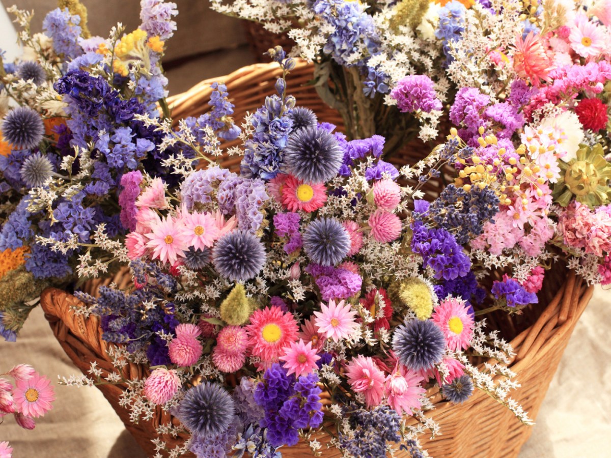 Getrocknete Blumensträuße in einem geflochtenen Korb.