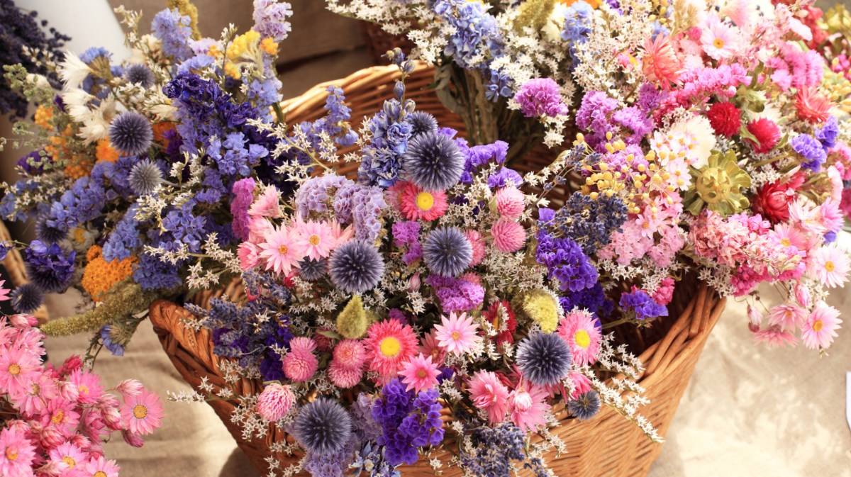 Getrocknete Blumensträuße in einem geflochtenen Korb.