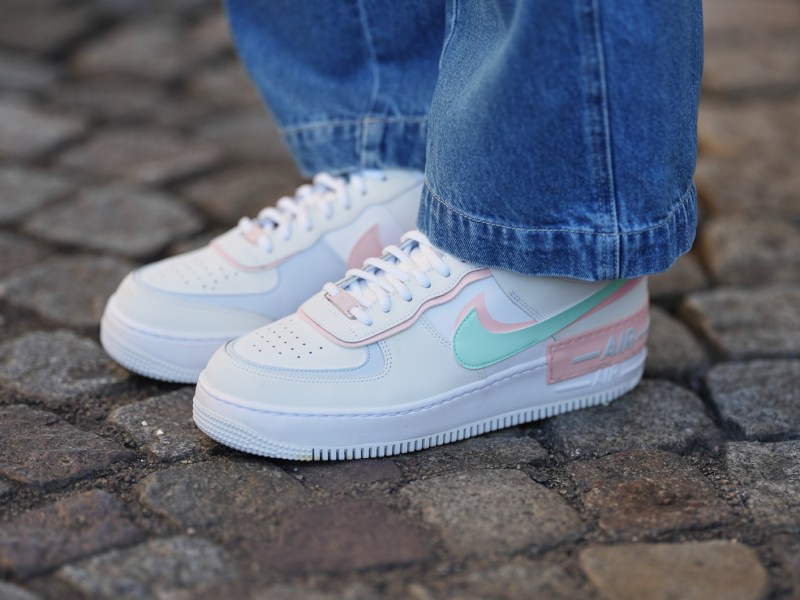 Weißer Sneaker von Nike mit farbigen Details zur blauen Jeans.