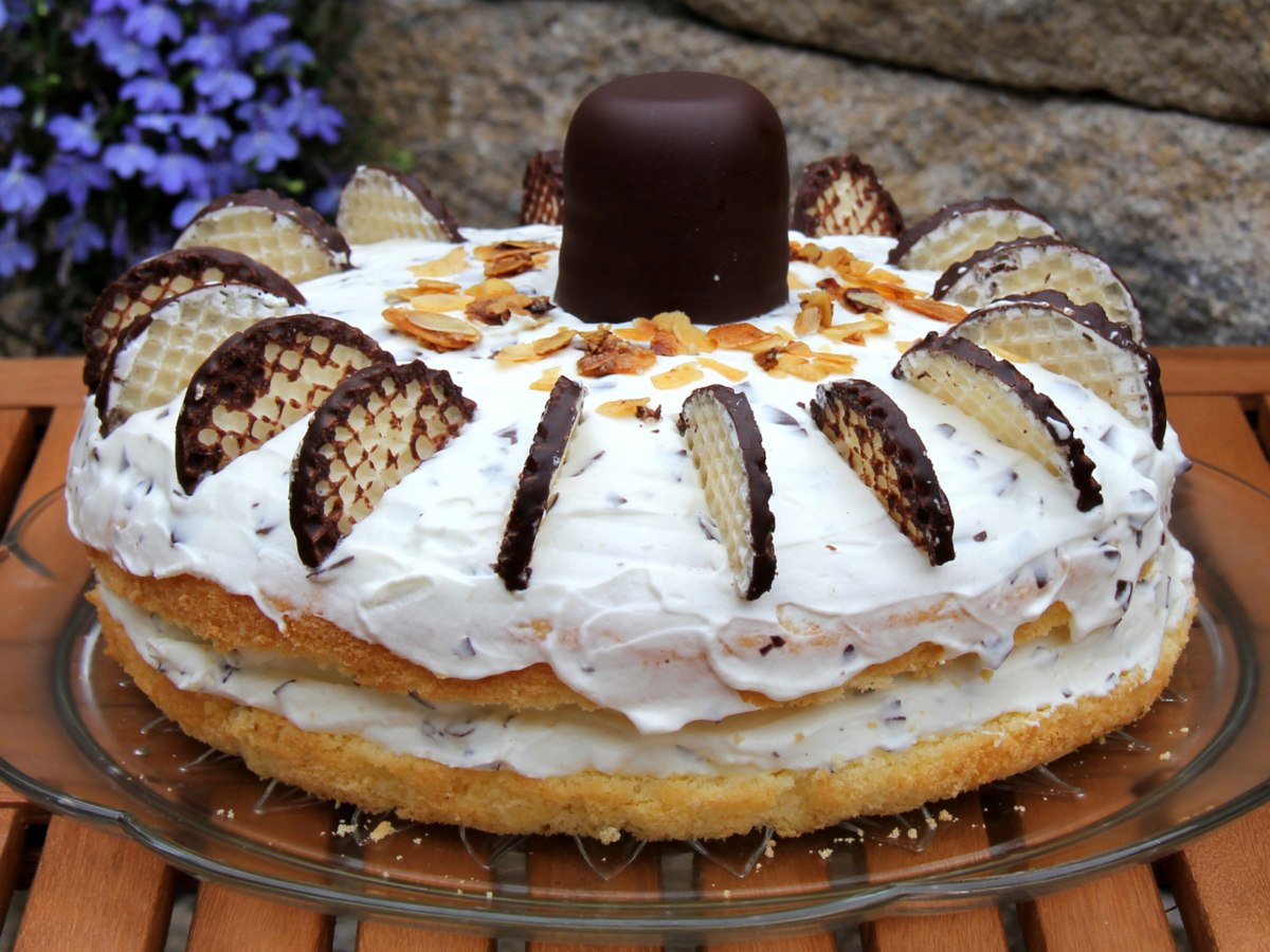 Torte mit Creme und Schokok&uuml;ssen auf einem Kuchenteller.