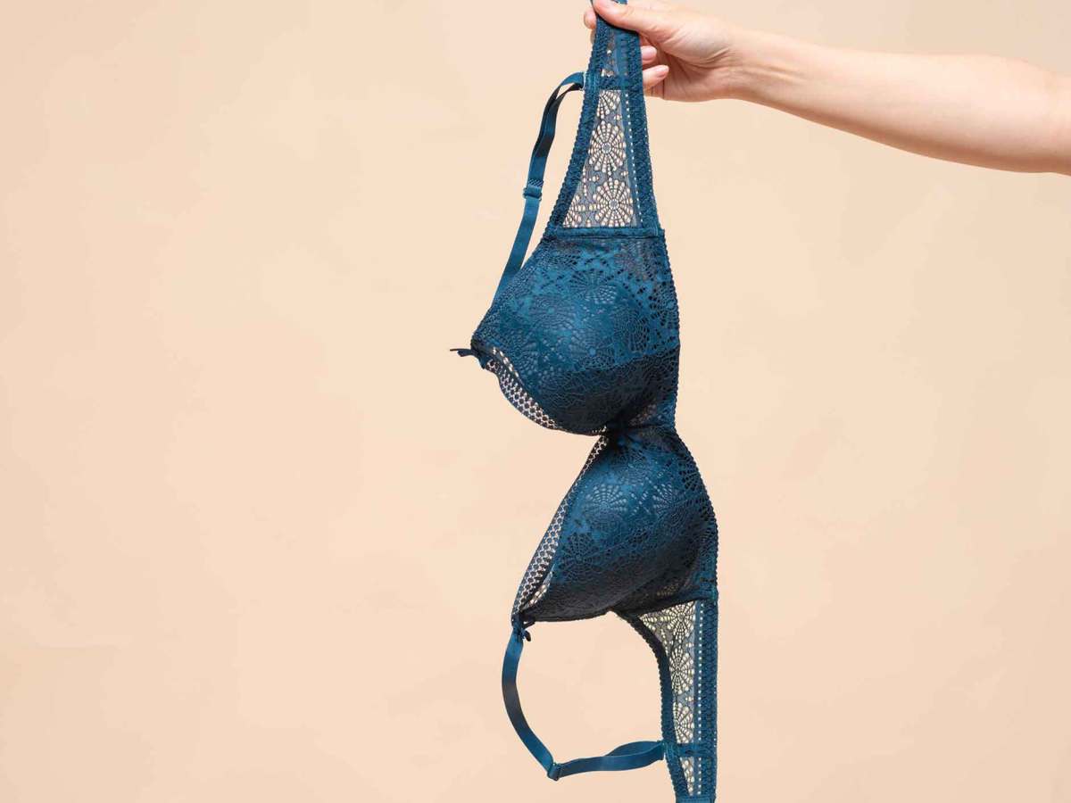 Ein ausgestreckter Arm h&auml;lt einen blauen Spitzen BH.