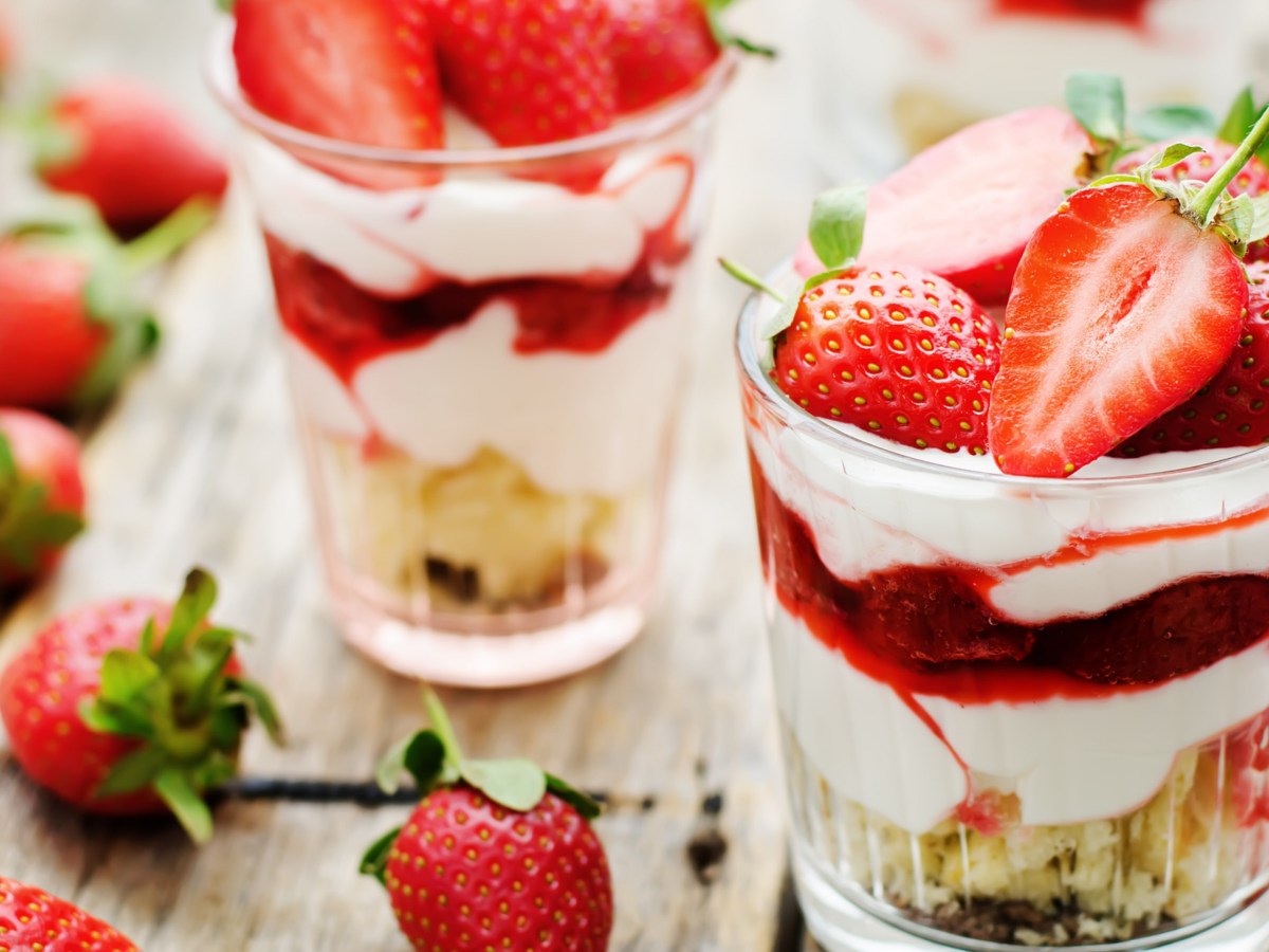 Nachtisch mit Keksen, Creme und Erdbeeren.