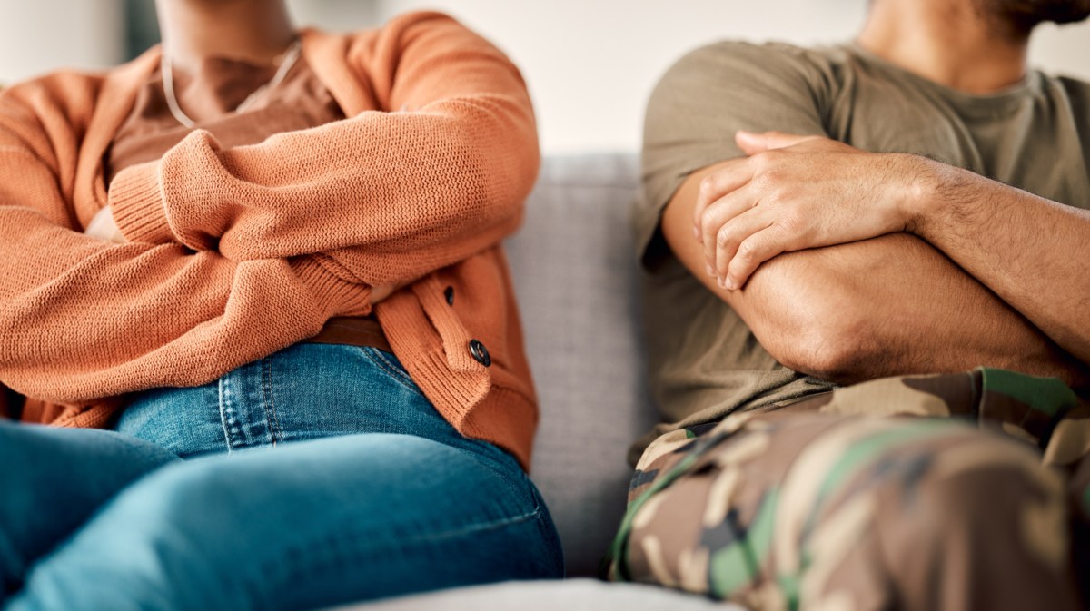 Frau und Mann auf der Couch mit eingeschränkten Armen