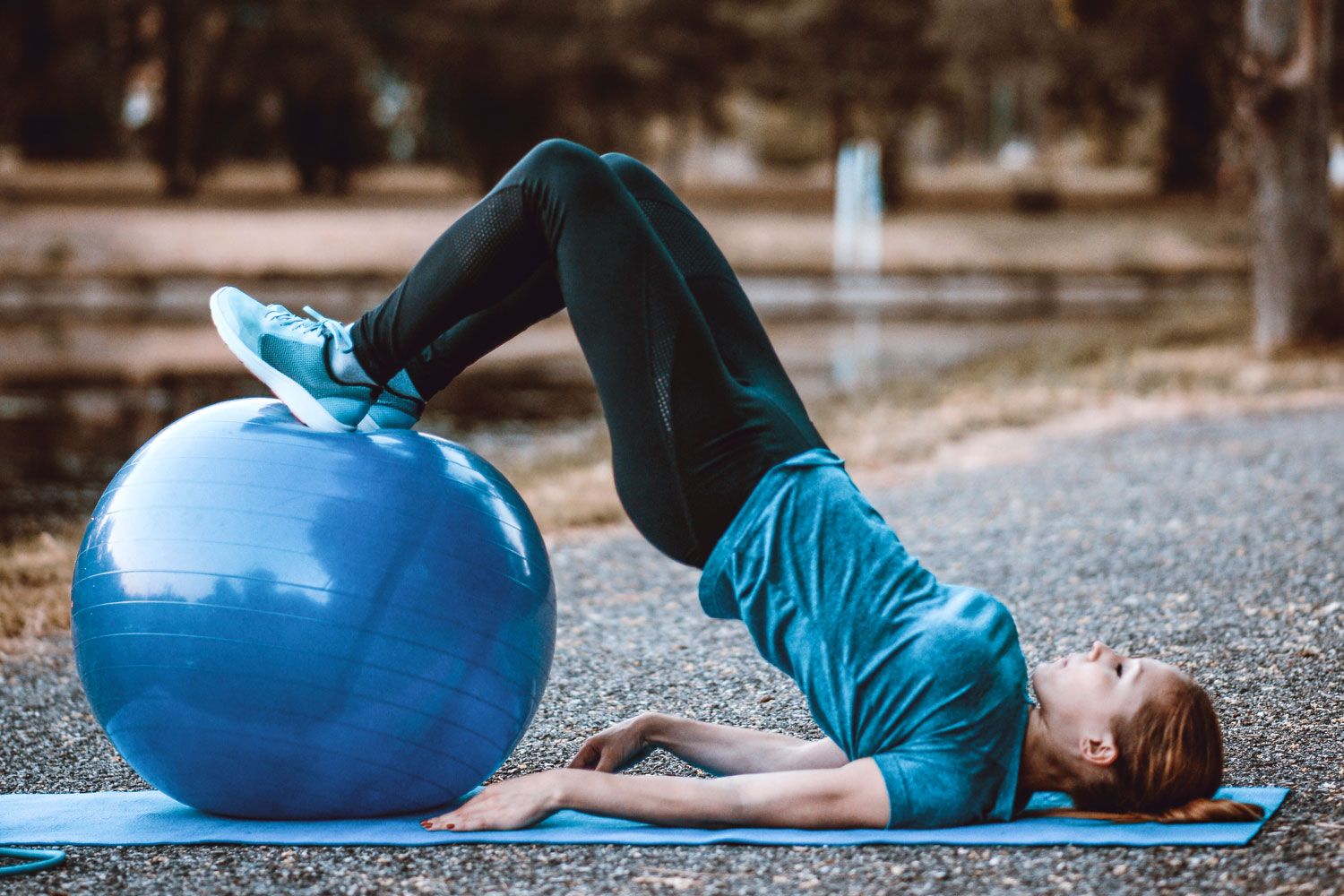 Weibliche Person trainiert ihren Po mit einem Ball