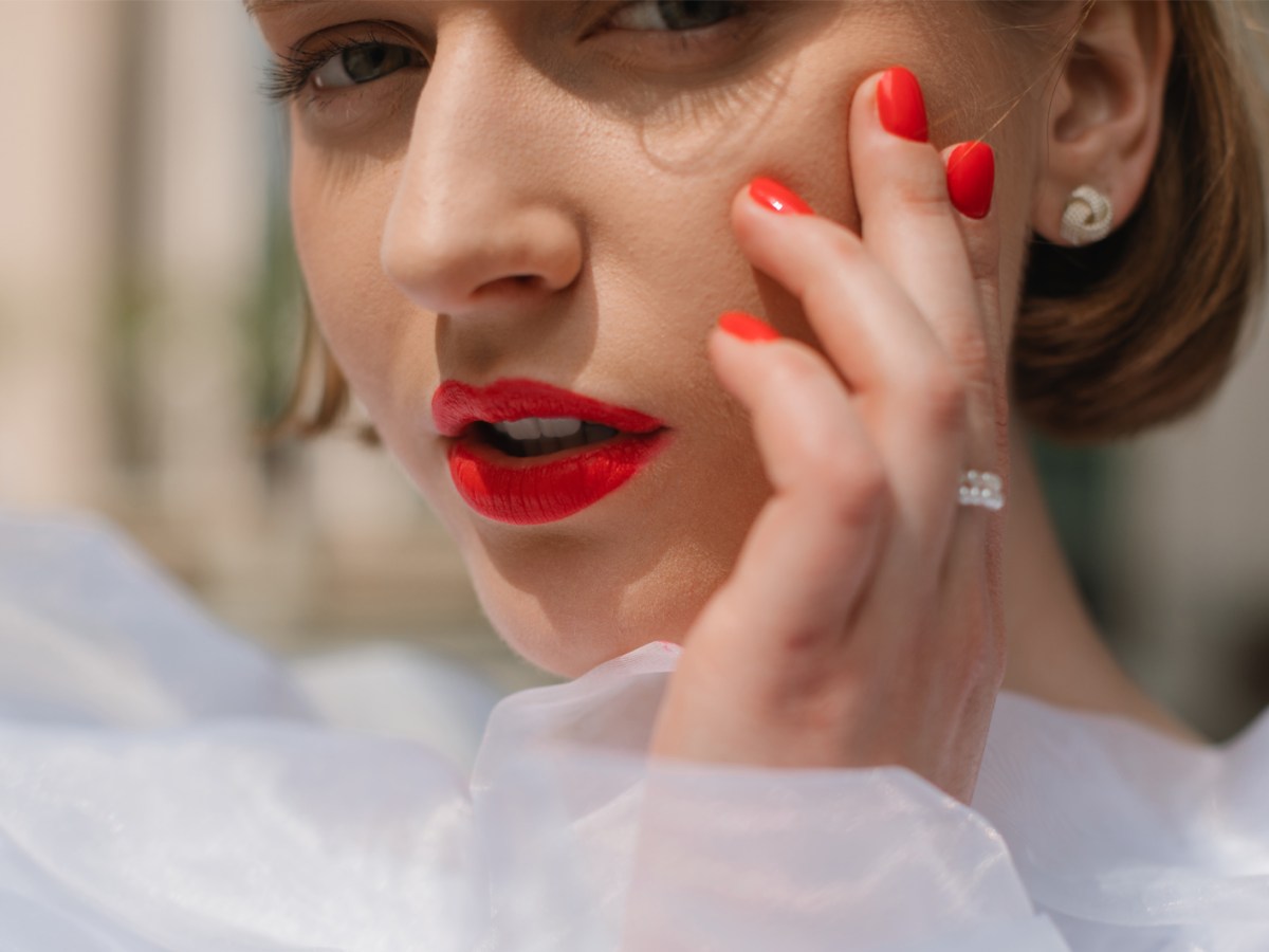 Frau mit roten Lippen und roten N&auml;geln.