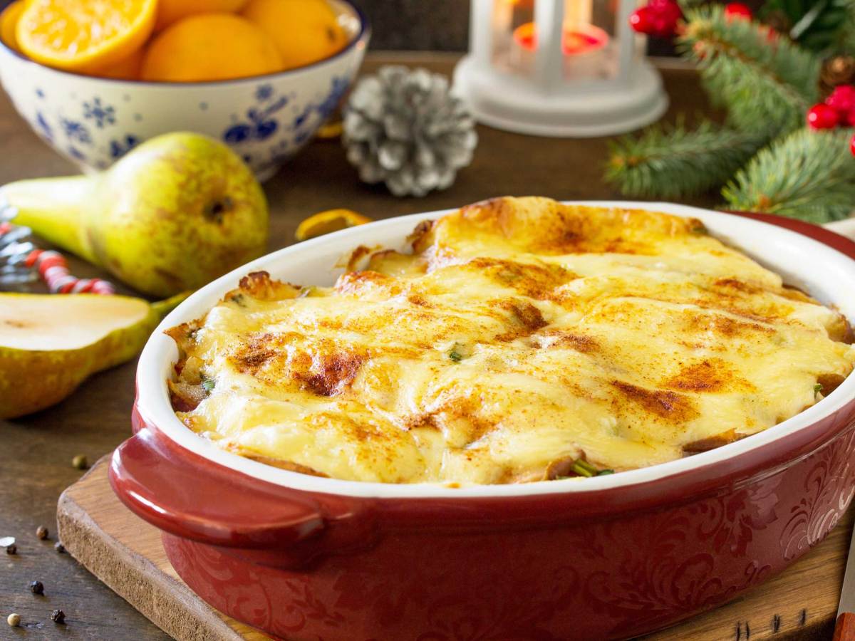 Kartoffelgratin mit Birne, Raclette-K&auml;se und Speck auf einer festlichen Weihnachtstafel