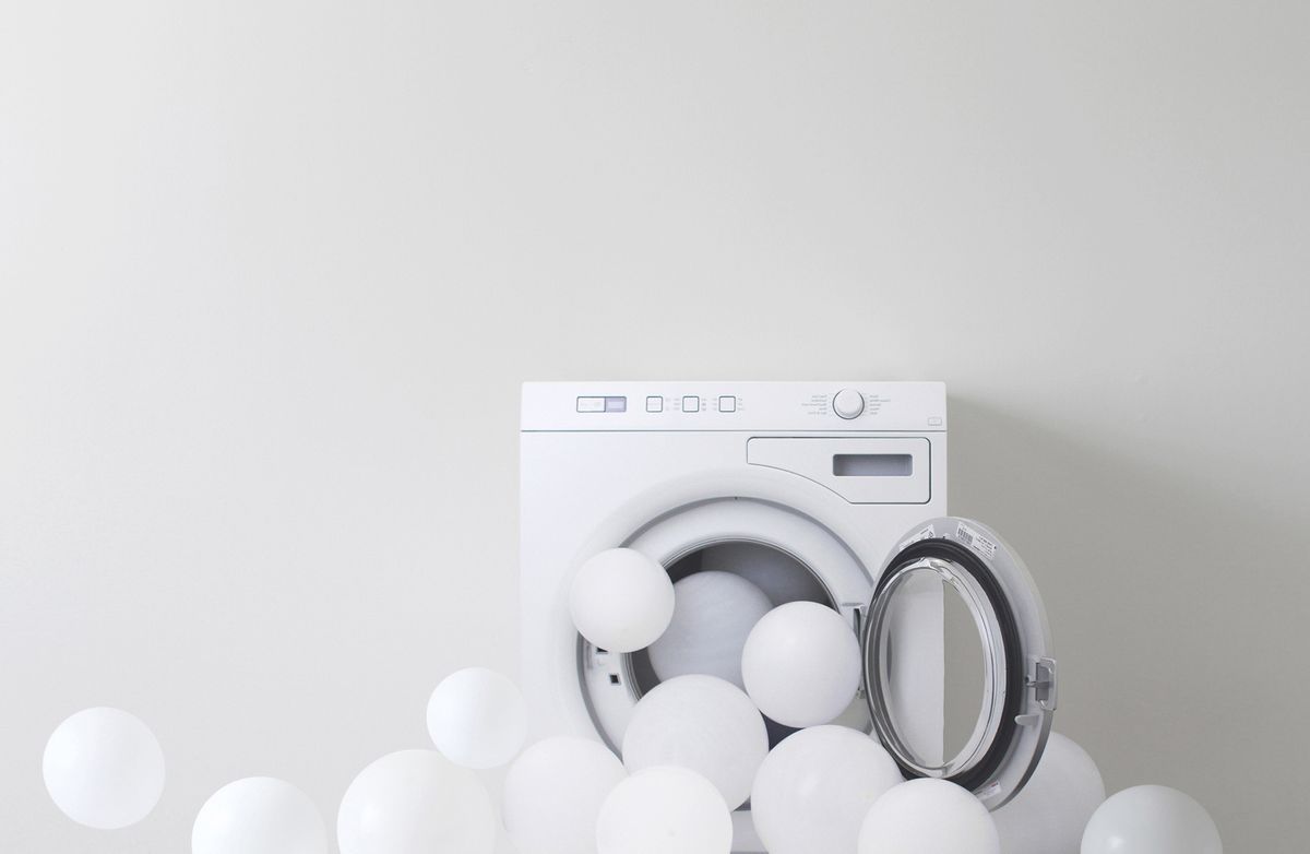 Waschmaschine mit weißen Ballons.