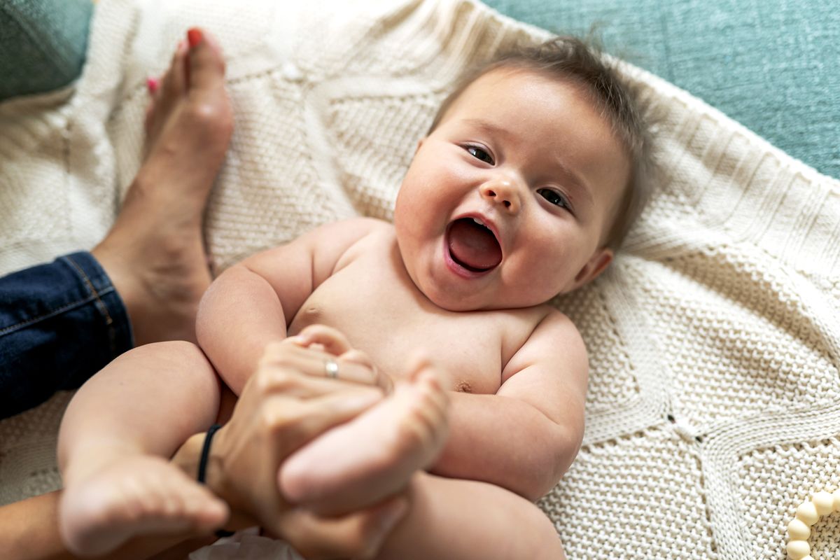 Baby liegt auf einem Handtuch und hat Spa&szlig;.