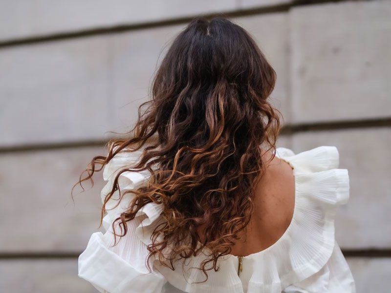 Frau mit langen lockigen Haaren.