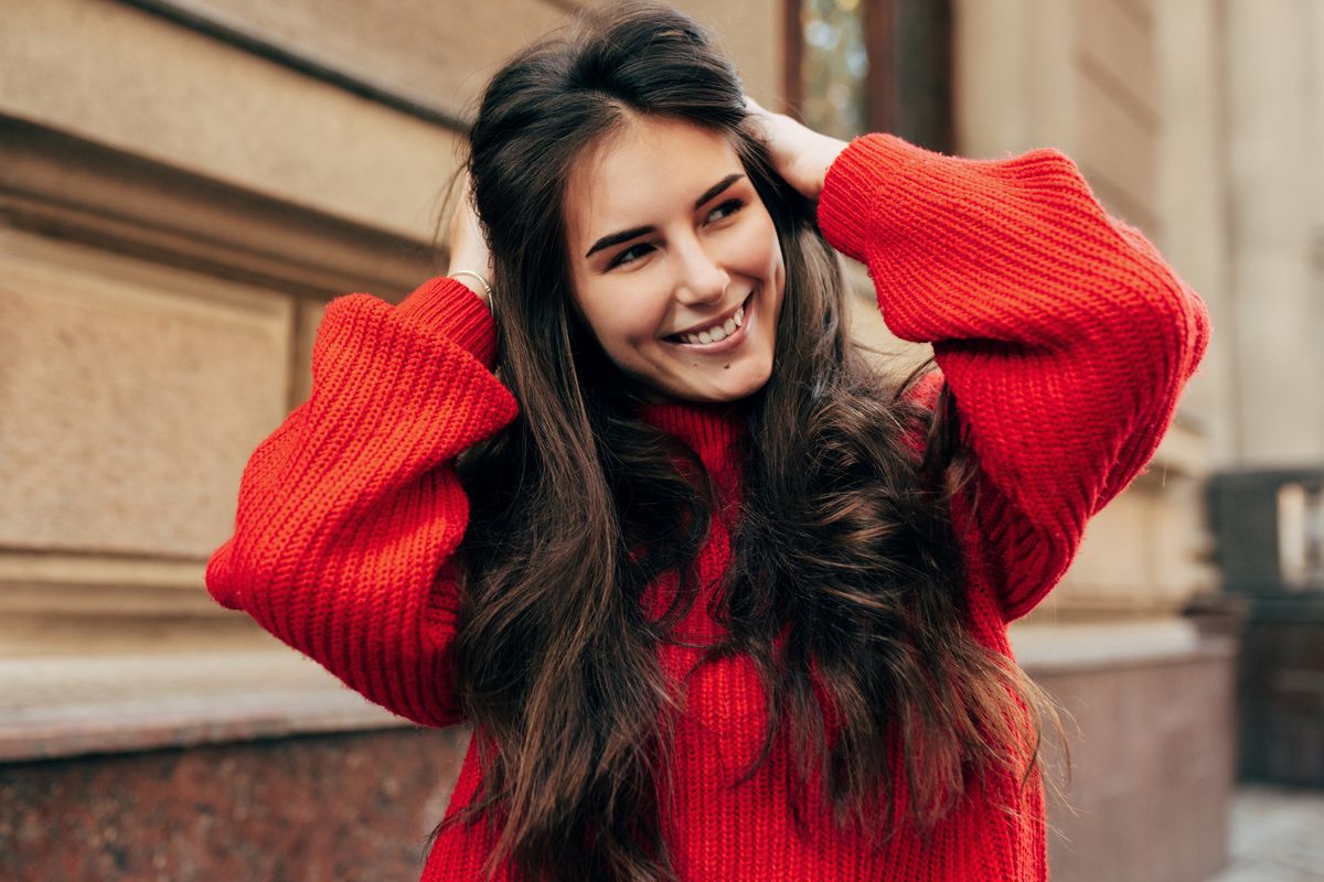 Frau mit schönen langen Haaren und rotem Pullover.