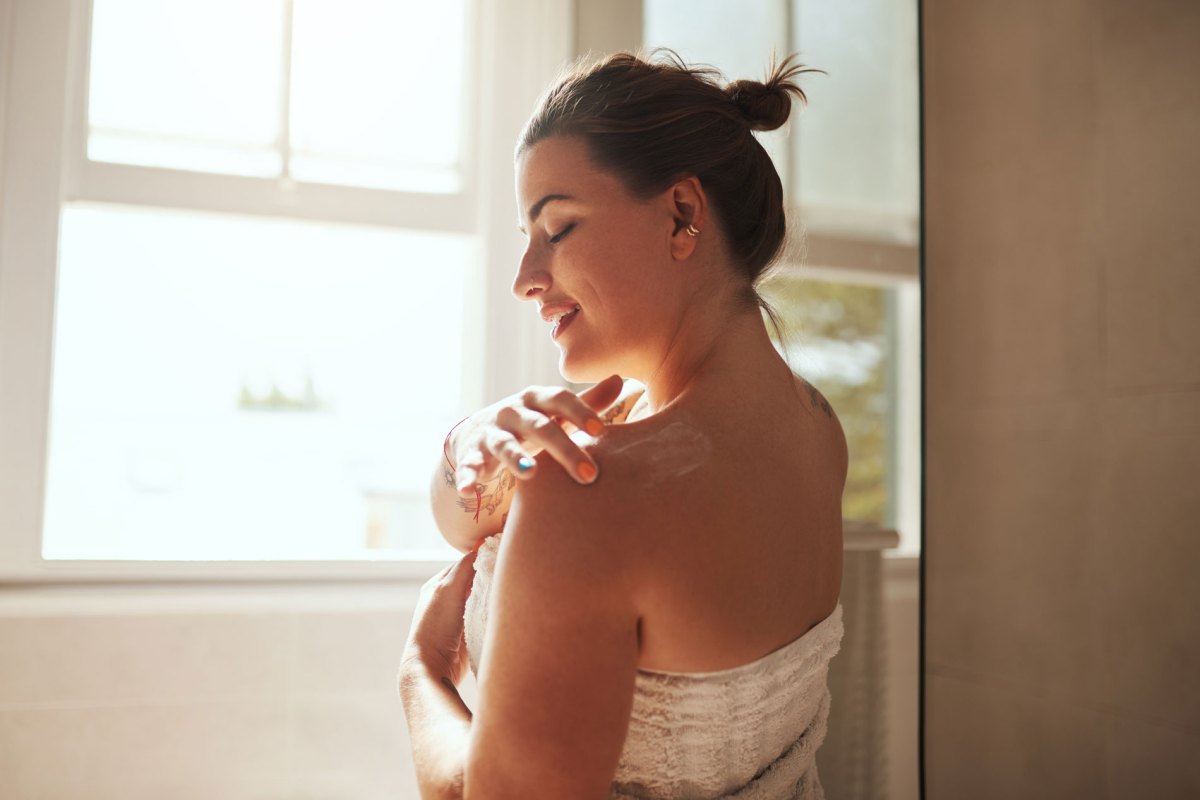 Frau beim Eincremen mit Bodylotion