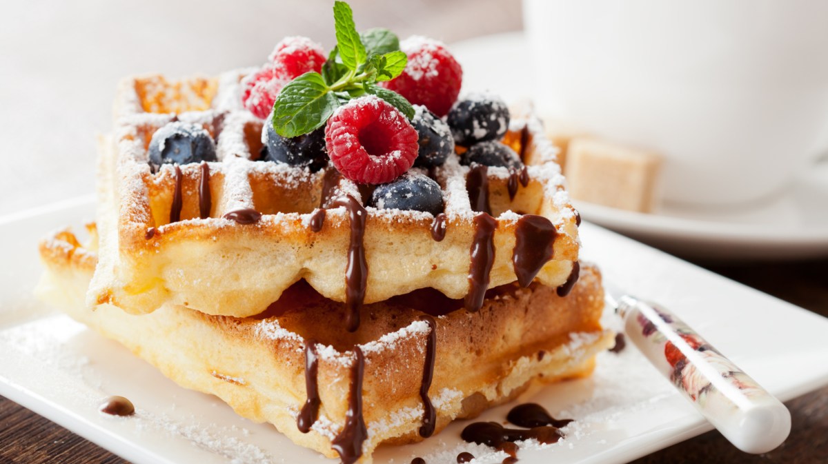 Belgische Waffeln auf weißem Teller, mit Puderzucker.