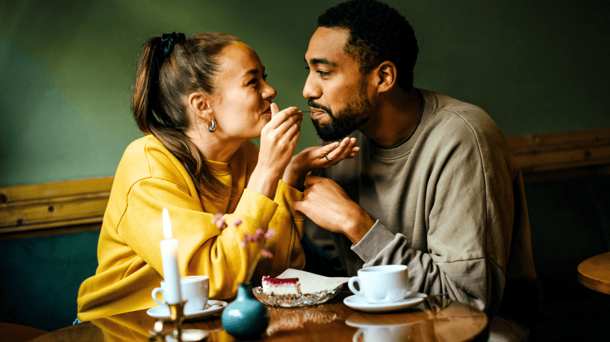 Pärchen isst Kuchen, Frau füttert ihren Freund.