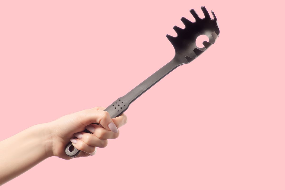 Hand mit schwarzem Spaghetti L&ouml;ffel