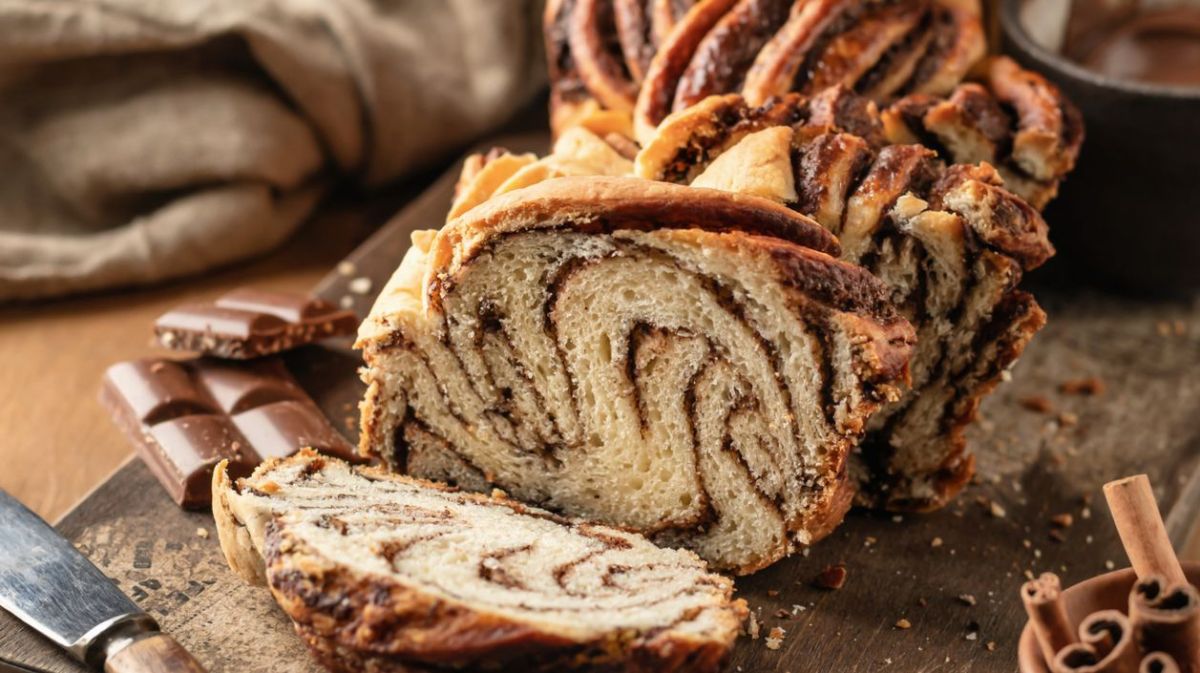 Babka mit Schokoladenfüllung auf rustikalem Holzbrett.