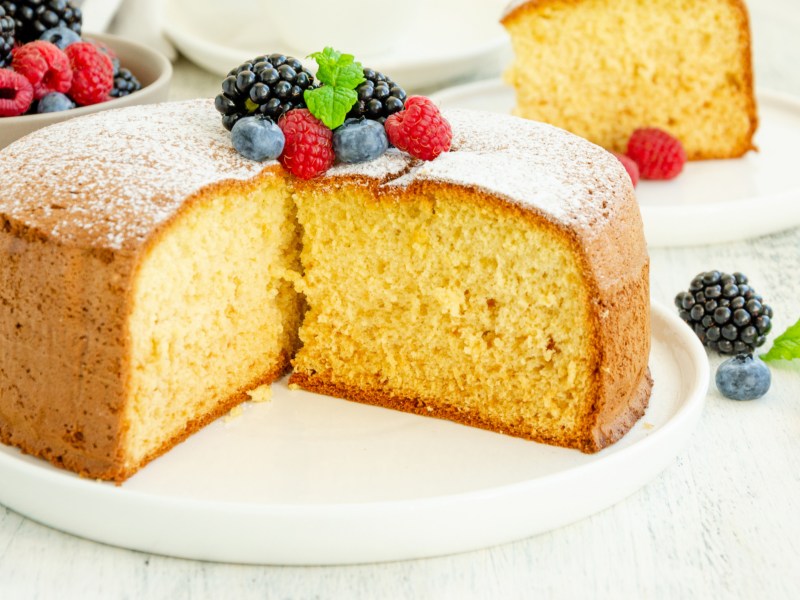 Ein heller Kuchen mit Beeren auf einem Teller.