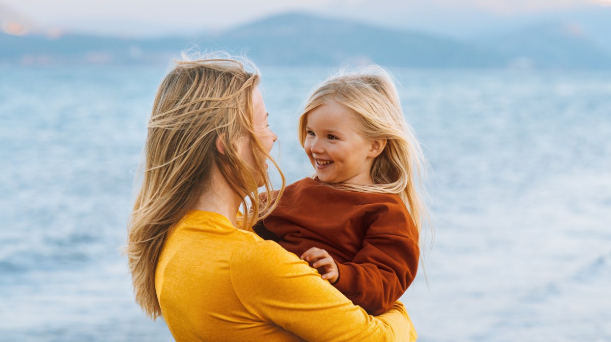 Mutter und Kind Tochter im Freien im Hintergrund eine Seelandschaft