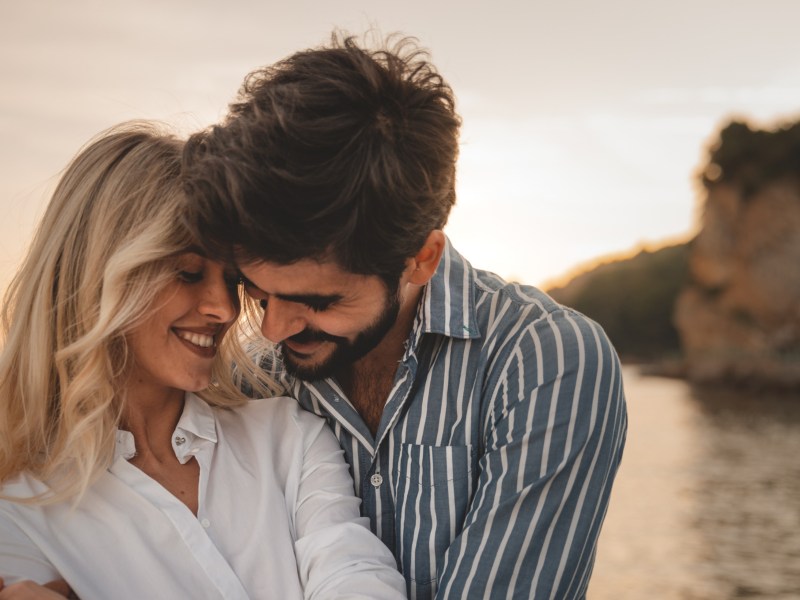 Mann und Frau am Strand, die sich verliebt anschauen