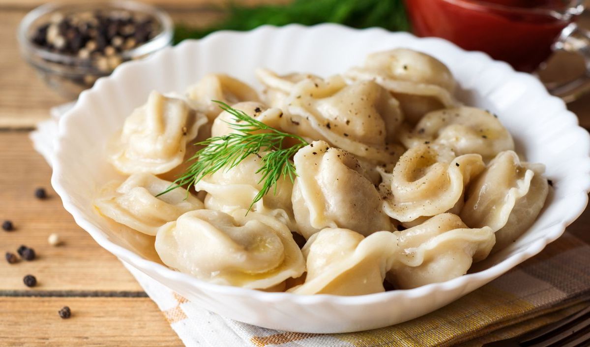 Russische Pelmeni in einer weißen Schüssel.