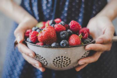 Obst Frische Bio-Beeren. Hände halten frische, saftige Beeren, Nahaufnahme