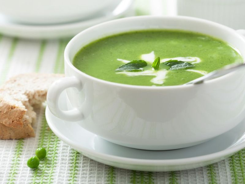 Erbsensuppe in einer Schüssel, daneben Brot