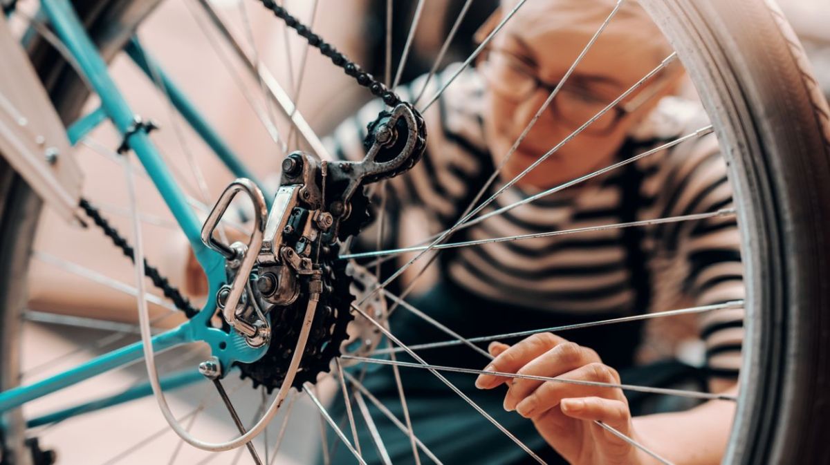 Eine Frau reinigt oder repariert ihr Fahrrad