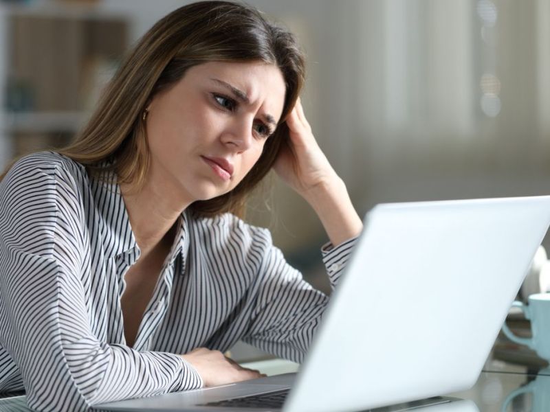 Frau sitzt gestresst vor dem Laptop. 