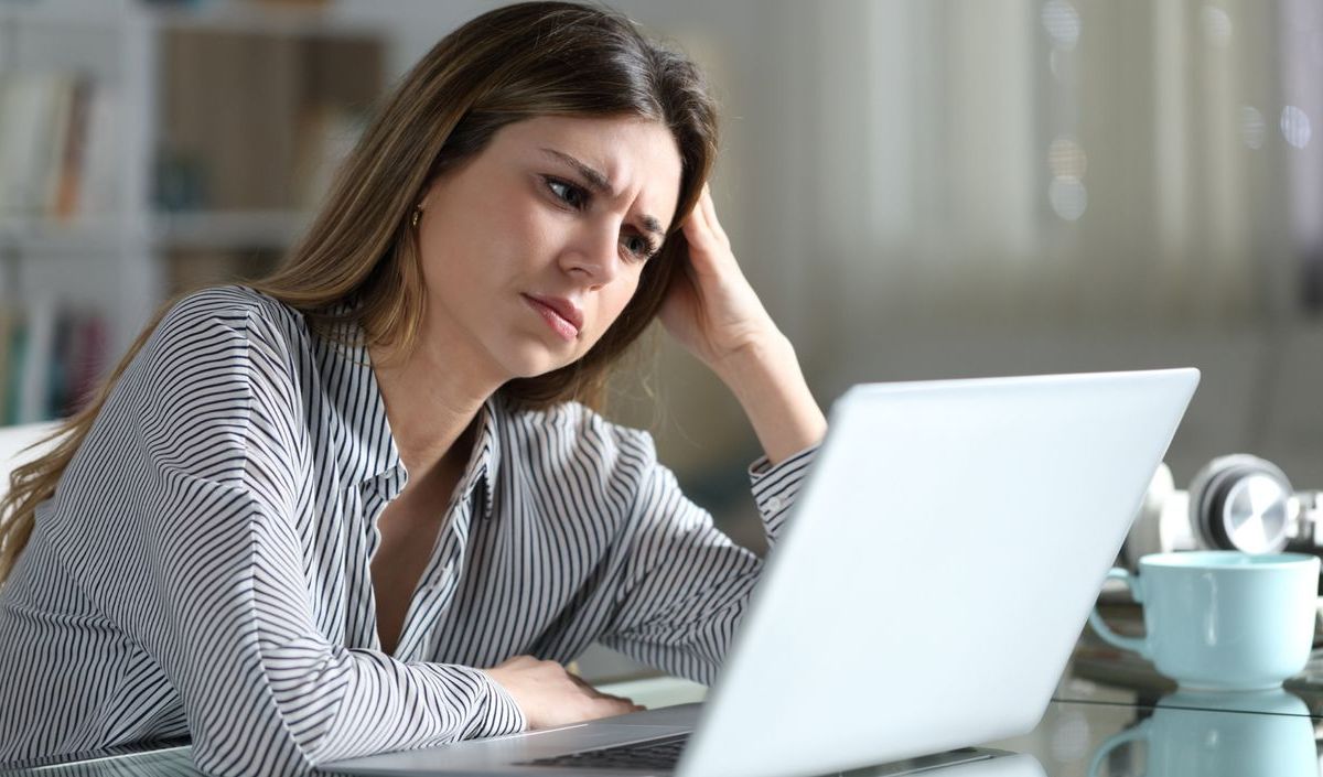 Frau sitzt gestresst vor dem Laptop. 