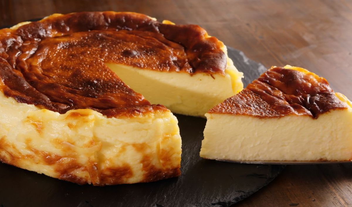 Joghurt-Kuchen auf dunkler Schieferplatte.