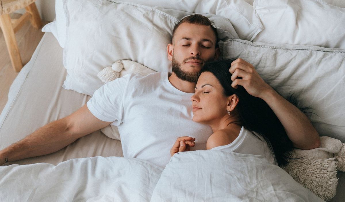 Pärchen kuschelt im Bett.