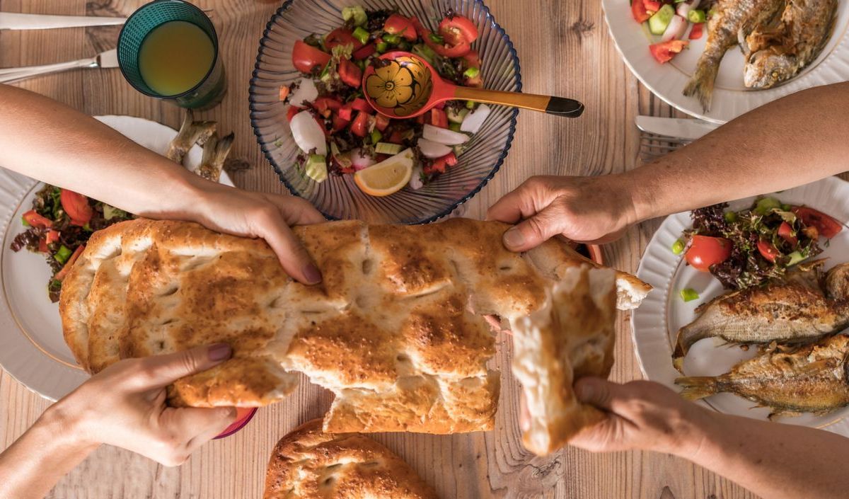 Familie teilt sich während Ramadan das Brot neben anderen Gerichten 